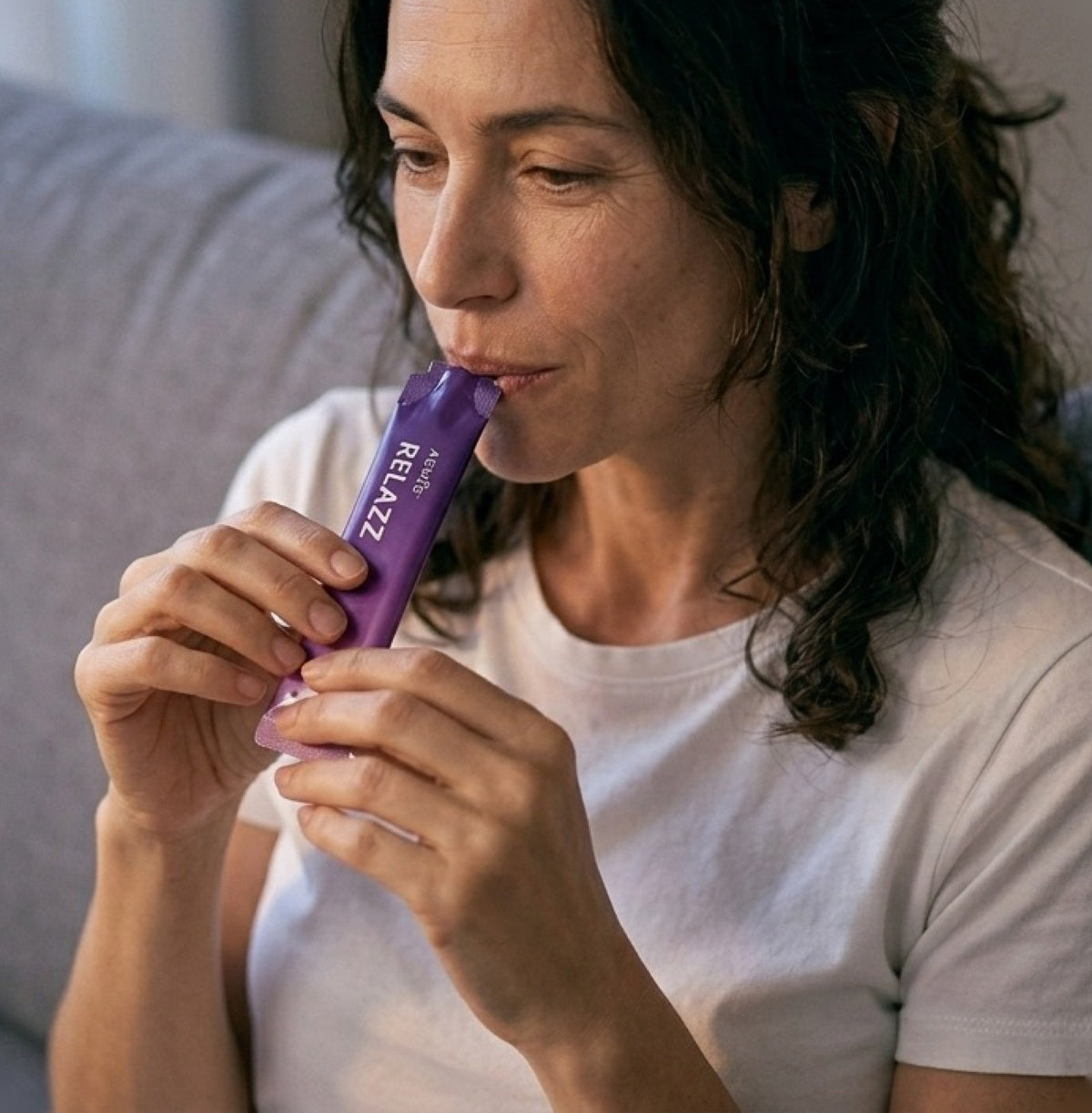 Woman sipping a RELAZZ sachet