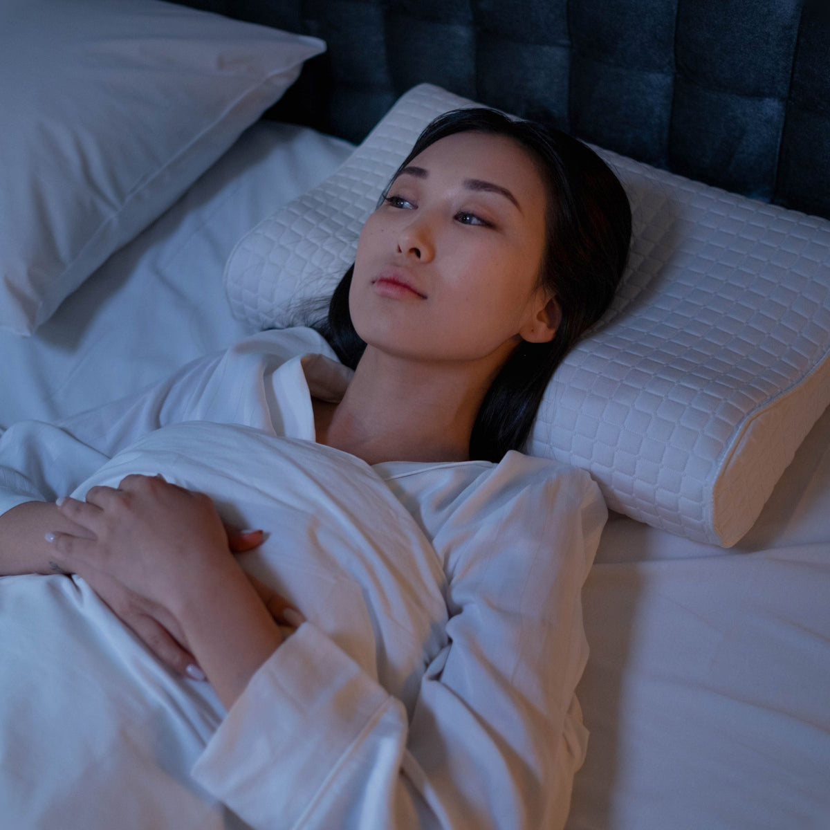 Woman lying awake in bed at midnight